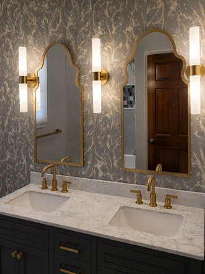 Double bathroom vanity with decorative mirrors and gold fixtures by KNA Remodeling