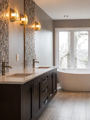 Bathroom remodel with double vanity and freestanding soaking tub by KNA Remodeling