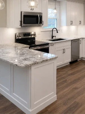Kitchen remodeling with white cabinetry, granite countertops, island, and updated flooring by KNA Remodeling