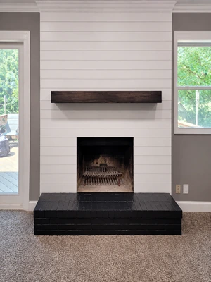 Stone fireplace feature wall with mantel and built-in shelving.