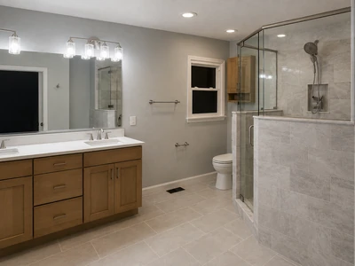 Bathroom remodel with tiled walk-in shower, wood vanity, and light gray finishes.