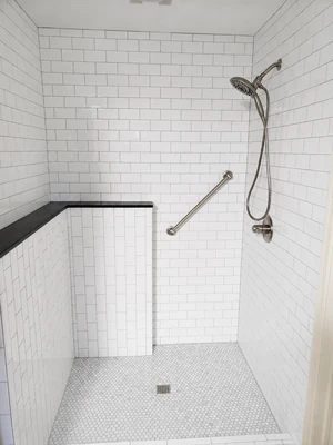 Walk-in shower with grab bars, hand-held shower fixture, and white subway tile by KNA Remodeling